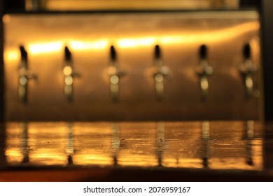 Bar Surface With Beer Taps In The Background (unfocused)