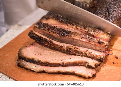 Barbecue beef brisket being cut on cutting board