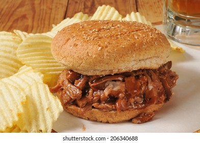 A Barbecue Beef Or Pulled Pork Sandwich With A Mug Of Beer