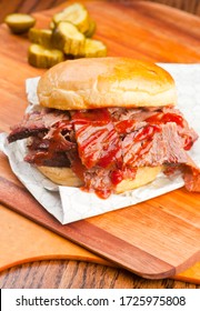 Barbecue Brisket Sandwich With Bbq Sauce And Pickles. Traditional Texas BBQ: Beef Brisket, Beef Ribs, Pork Ribs, Sausage Links, Black Pepper Roasted Chicken, And Turkey Served With Homemade Sauce.