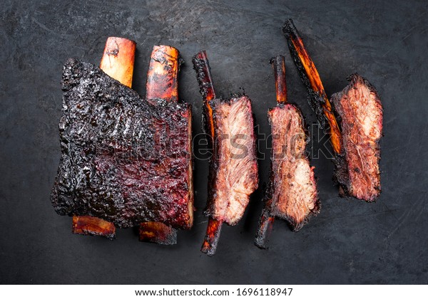 Barbecue burnt\
chuck beef ribs marinated and sliced with hot chili sauce as top\
view on an old rustic metal sheet\
