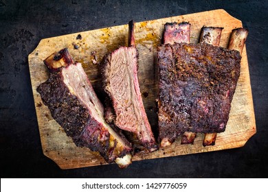 Barbecue chuck beef ribs with hot rub as top view sliced on a wooden cutting board 