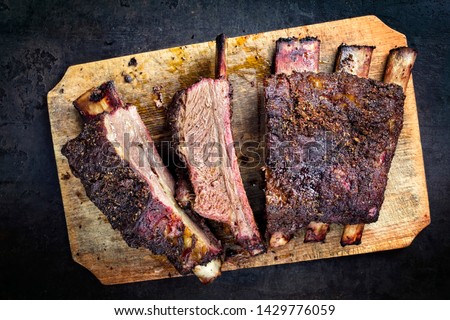 Barbecue chuck beef ribs with hot rub as top view sliced on a wooden cutting board 