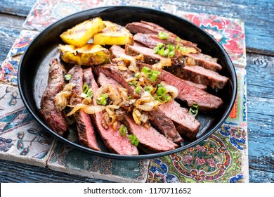 Barbecue Dry Aged Wagyu Flank Steak With Pineapples And Onion Rings As Closeup On A Plate