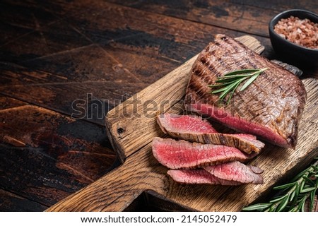 Barbecue dry aged wagyu Flank Steak on a cutting board. Wooden background. Top view. Copy space.