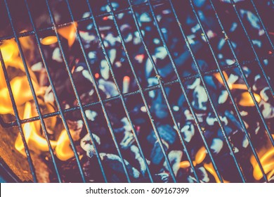 barbecue grid against flames from charcoal, food background