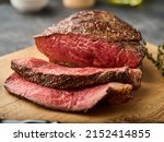 Barbecue Grilled rump cap or brazilian picanha beef meat steak in a wooden tray. Grey background. 