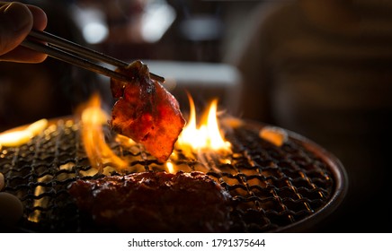 Barbecue Grilling Beef Meat On Fire And Net In Korean Traditional Style With Shopstick 