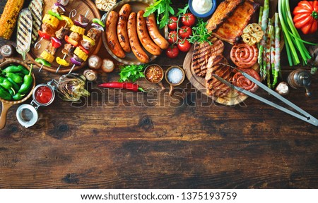 Barbecue menu. Grilled meat and vegetables on rustic wooden table with copy space for text