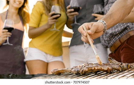 Barbecue Party Outside. Friends Grilling Meat On Bbq Grill And Drinking Red Wine