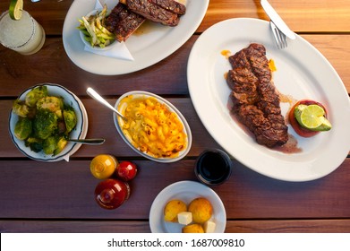 Barbecue. Picnic BBQ Table Spread. Beef Brisket, Chicken, Pork Ribs, Beef Ribs, Mac N Cheese, Cornbread, Brussels Sprouts, Coleslaw, And Beer. Classic Traditional Texas Bbq Meats And Side Dishes.