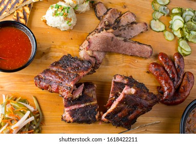 Barbecue Platter. Texas BBQ Platter: Pork Ribs, Brisket, Pork Sausage, Pickles, Bbq Sauce, Potato Salad, Baked Beans.