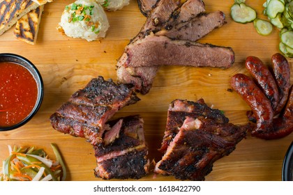 Barbecue Platter. Texas BBQ Platter: Pork Ribs, Brisket, Pork Sausage, Pickles, Bbq Sauce, Potato Salad, Baked Beans.