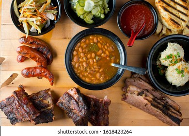 Barbecue Platter. Texas BBQ Platter: Pork Ribs, Brisket, Pork Sausage, Pickles, Bbq Sauce, Potato Salad, Baked Beans.