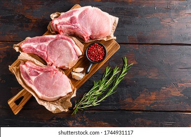 barbecue pork portion set over old rustic dark wood table with herbs and ingrefients top view space for text