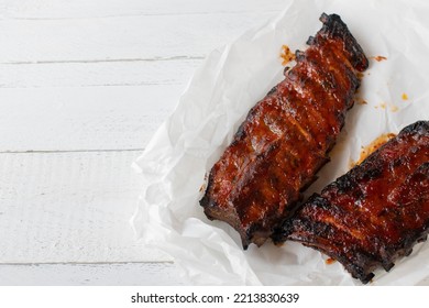 Barbecue Pork Ribs On White Wooden Background. Overhead View With Copy Space