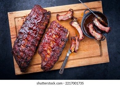 Barbecue pork spare loin ribs St Louis cut with hot honey chili marinade burnt as top view on a wooden cutting board  - Shutterstock ID 2217001735