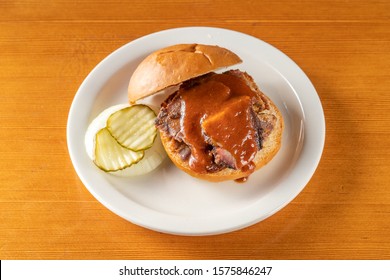 Barbecue Pulled Pork Sandwich Served On A Bun With Tangy Southern Bbq Sauce And Homemade Pickles.