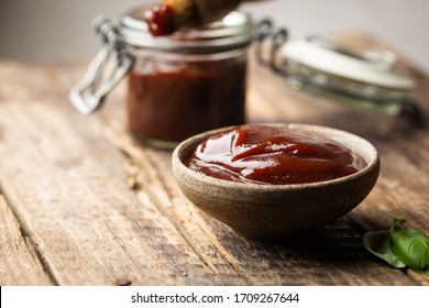 Barbecue sauce in a saucer with basting brush over rustic barn wood table with copy space. - Shutterstock ID 1709267644