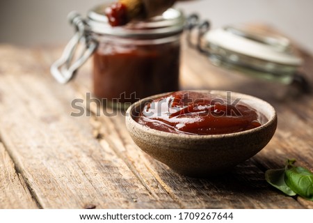 Barbecue sauce in a saucer with basting brush over rustic barn wood table with copy space. Stockfoto © 