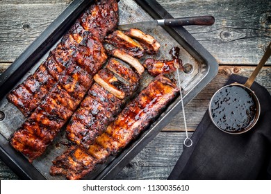Barbecue spare ribs St Louis cut with hot honey chili marinade as top view in a rustic skillet 