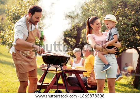 Barbecue time. Happy family make barbecue together in garden.