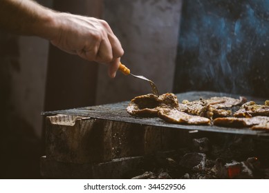 Barbecue time, man grilling pork meat chops, natural light, retro toned, selective focus with shallow depth of field. - Shutterstock ID 344529506