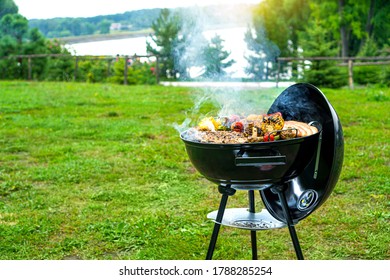 Barbecue time at the nature. BBQ grilling on the shore of a picturesque lake. Copy space. 
