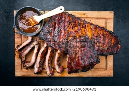 Barbecue veal spare loin ribs St Louis cut with hot honey chili marinade burnt as top view on a rustic wooden cutting board 