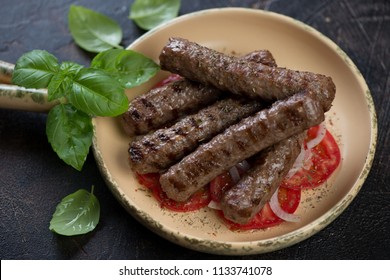 Barbecued Cevapcici Or Skinless Beef Sausages Served With Tomatoes And Onion, Traditional Dish In The Balkans, Horizontal Shot