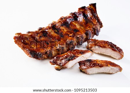 Barbecued and marinated sticky spare ribs on a white background with copy space.