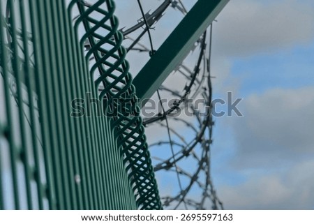 Barbed razor wire on a high-security building. Barbed wire and hard wire fence. Concepts for jails, army facilities, nuclear power plants, and defense against illegal migration.