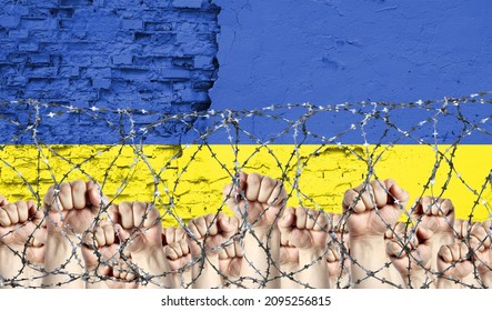 Barbed wire against the background of the inflicted flag of Ukraine and raised fists - Powered by Shutterstock