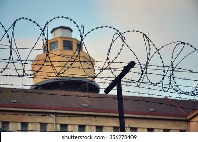 Barbed wire fence attached around prison walls