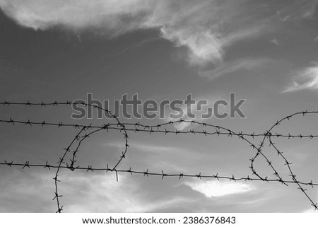 Similar – Fence with a barbed