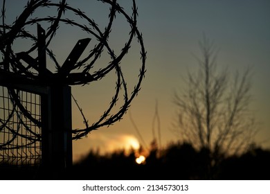 Barbed wire fence and Light of Hope. - Shutterstock ID 2134573013