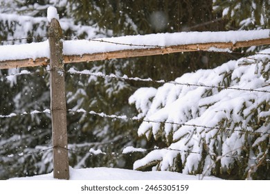 a barbed wire fence on a snowed in mountain meadow at a snowy spring day - Powered by Shutterstock
