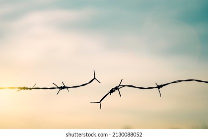 Barbed wire fence with sunset Twilight sky. Chain spike for world war fail argue boundary concept for human rights slave, prisoners hostage broke to freedom. liberty day. russia ukraine world war
