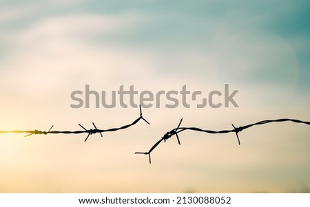 Barbed wire fence with sunset Twilight sky. Chain spike for world war fail argue boundary concept for human rights slave, prisoners hostage broke to freedom. liberty day. russia ukraine world war