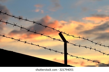 Barbed wire fence with Twilight sky to feel Silent and lonely and want freedom.
