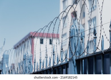 Barbed Wire And Metal Fence At The Entrance To Prison Or Military Base. Safety And Freedom Concept