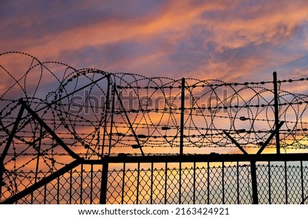 Similar – Fence with a barbed