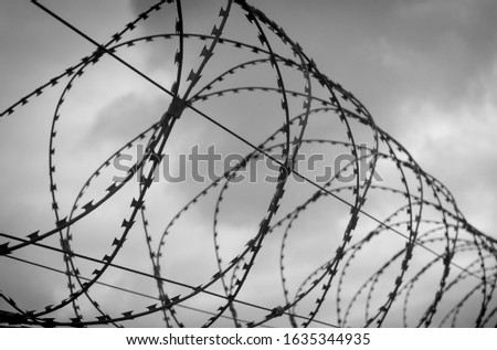 Similar – Fence with a barbed