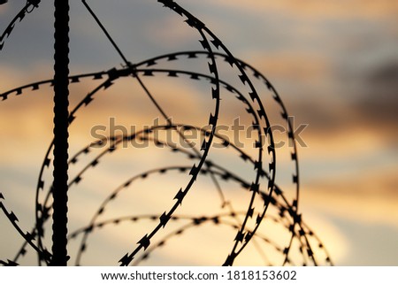 Similar – Fence with a barbed