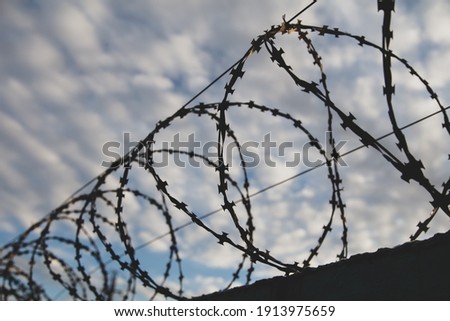 Similar – Fence with a barbed