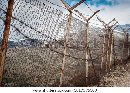 Barbed wire on fence of a private area around Israeli settlements on Golan heights, Israel. Protective fencing of specially protected object of barbed wire. Stamped barbed wire.