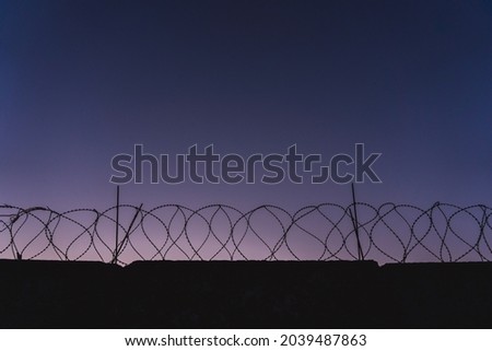 barbed wire prison wall. sunset panorama