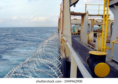 Barbed Wire Or Razor Wire Attached To The Ship Hull, Superstructure And Railings To Protect The Crew Against Piracy Attack Passing Gulf Of Guinea In West Africa.