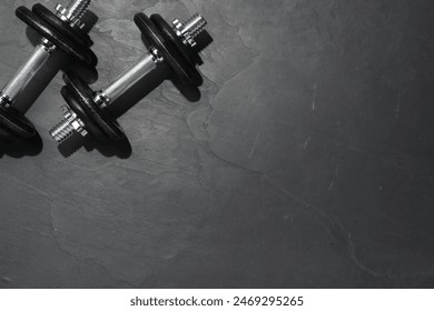 Barbells on dark textured floor, top view. Space for text - Powered by Shutterstock