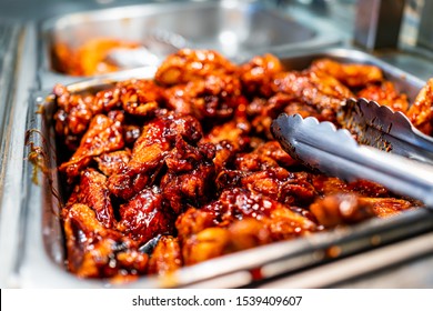 Barbeque Sauce Chicken Wings Buffet Bar Self Serve With Tongs In Grocery Store, Restaurant Or Catering Event With Red Color Unhealthy Food